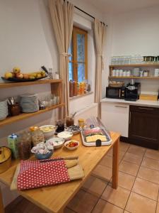 a kitchen with a wooden table with food on it at Pension Fuchsmühle in Rothenburg ob der Tauber