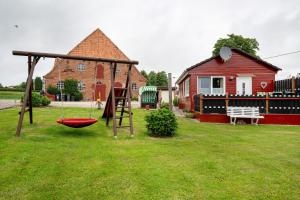 a playground in a yard next to a house at Ferienhaus Landhaus Loose in Schashagen