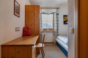 a bedroom with a desk and a bed and a window at Malsötscherhof Apt A in Villandro