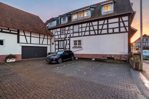 a car parked in a parking lot in front of a house at Le Quartier Blackforest-Straßburg in Willstätt