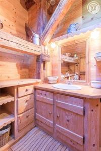 a bathroom with a sink in a log cabin at Chalet de Marie proche des Saisies in Queige +32 photos