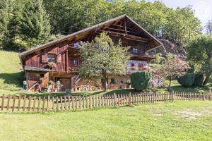 a wooden house with a fence in front of it at Chalet de Marie proche des Saisies in Queige
