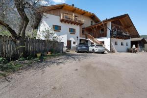 a house with two cars parked in front of it at Regalterhof Eppan in San Paolo