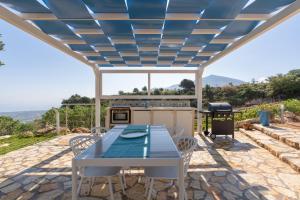 a patio with a table and chairs under a pergola at Dome on the hill with Jacuzzi in Castellammare del Golfo