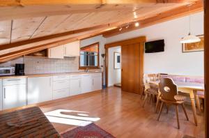a kitchen and dining room with a table and chairs at Haus Peer Burgeis in Malles Venosta