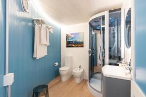 a blue bathroom with a toilet and a sink at Dome on the hill with Jacuzzi in Castellammare del Golfo