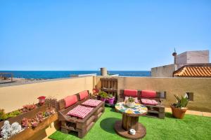 a rooftop patio with a table and chairs and the ocean at Estudio Calima in Arico