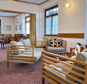 a waiting room with chairs and a couch and tables at Casa Arcobaleno in Airolo