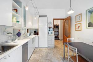 a kitchen with white cabinets and a black counter top at Casa Rose di Mare in Albenga