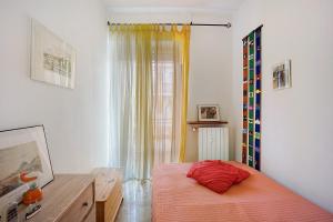 a bedroom with a bed and a dresser and a window at Casa Rose di Mare in Albenga