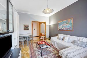 a living room with a white couch and a table at Casa Rose di Mare in Albenga