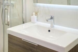 a white bathroom sink with a soap bottle on it at Studio - 2 couchages doubles in Villeneuve-Loubet +15 photos
