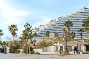 a large building with palm trees in front of a house at Studio - 2 couchages doubles in Villeneuve-Loubet