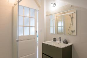 a bathroom with a sink and a shower and a mirror at Le Gite De Luca in Husseren-les-Châteaux +17 photos