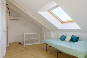 a attic bedroom with a bed and a skylight at Le Gite De Luca in Husseren-les-Châteaux