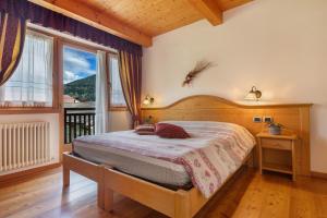 a bedroom with a bed and a large window at Agritur Maso Pan in Caderzone Terme