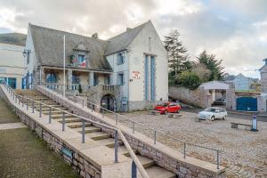 a building with a staircase in front of a parking lot at Appartement Les Bains - Erquy in Erquy