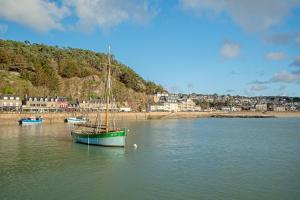 a boat sitting in the water next to a beach at Appartement Les Bains - Erquy in Erquy +12 photos