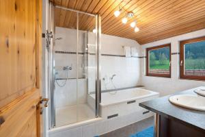 a bathroom with a shower and a tub and a sink at Wohnung Kuhblick in Baiersbronn +26 photos