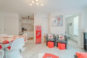 a living room with a table and chairs and a kitchen at Appartement Les Bains - Erquy in Erquy