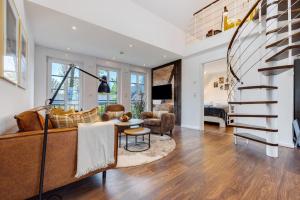 a living room with a couch and a spiral staircase at Ferienwohnung Oertzheide in Hermannsburg