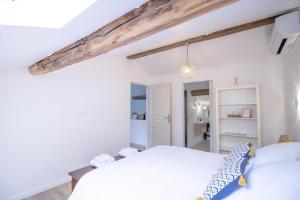 a bedroom with white walls and a bed with blue pillows at A Casa D'amore in Bastelica