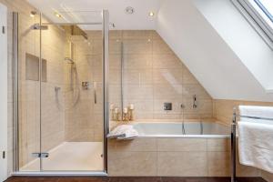 a bathroom with a shower and a tub at Ferienwohnung Oertzheide in Hermannsburg +20 photos