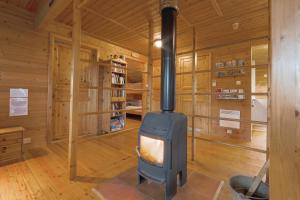 a woodburning stove in a room in a cabin at Guesthouse / Huskyfarm Innset in Innset