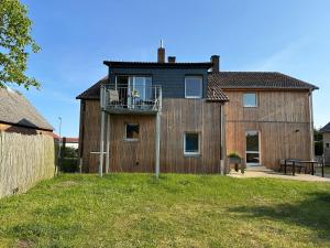 a large wooden house with a balcony on top of it at Urlaub auf dem Land in Triepkendorf