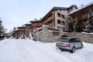 a car parked in the snow in front of a building at Le Châtelard in Val-d'Isère