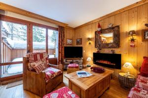 a living room with wooden walls and a fireplace at Le Châtelard in Val-d'Isère