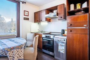 a kitchen with a stove and a table and a chair at 3Tre Patascoss-Madonna di Campiglio in Madonna di Campiglio +19 photos