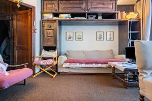 a living room with a bed and chairs in it at 3Tre Patascoss-Madonna di Campiglio in Madonna di Campiglio