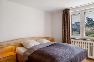 a bedroom with a bed and a window at Haus Lerchenweg B in Bad Wildungen