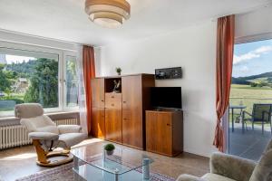 a living room with a tv and a couch and a table at Haus Lerchenweg B in Bad Wildungen