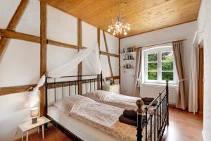 a bedroom with a bed with a wooden ceiling at Starenhof Ferienhaus in Schlagsdorf