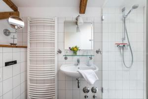 a white bathroom with a sink and a mirror at Ferienwohnung alter Heuboden in Steinbergkirche +24 photos