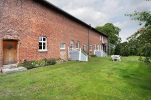 a brick building with a grass yard in front of it at Starenhof Ferienhaus in Schlagsdorf