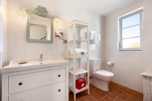 a bathroom with a sink and a toilet and a mirror at Bartolomeu Cottage - Portimão in Portimão +16 photos