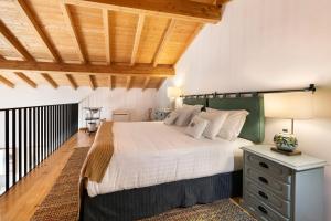 a bedroom with a large bed and a wooden ceiling at Bartolomeu Cottage - Portimão in Portimão
