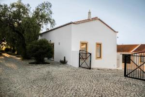 a white house with a gate in front of it at Bartolomeu Cottage - Portimão in Portimão