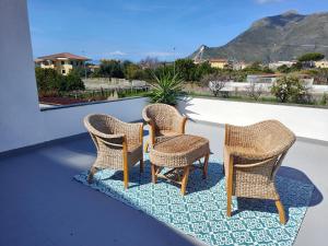 three wicker chairs sitting on top of a balcony at Casetta Esmeralda in Praia a Mare