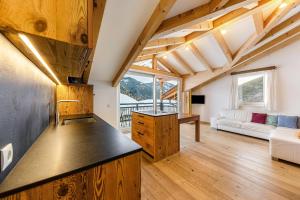 a kitchen and living room with wooden ceilings at Naturoase Stegerhof Apt Margerite in Trodena