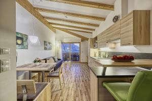 a kitchen and living room with a table and chairs at Feldhof Apartment Apfeloase in Caines
