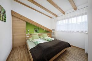 a bedroom with a large bed with a wooden headboard at Feldhof Apartment Apfeloase in Caines