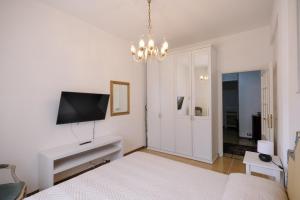 a white room with a bed and a television at Casa Parco Casale in Rapallo
