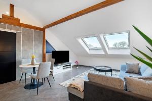a living room with a couch and a table at Le Quartier Blackforest-Straßburg in Willstätt