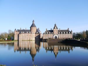 a large castle with its reflection in the water at Nostalgie Apartment in Kerken