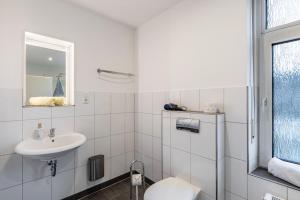 a white bathroom with a sink and a toilet at Nostalgie Apartment in Kerken