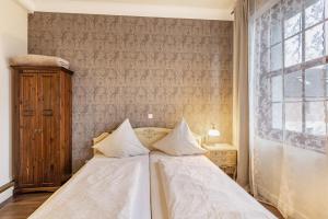 a bedroom with a bed with white sheets and a window at Nostalgie Apartment in Kerken